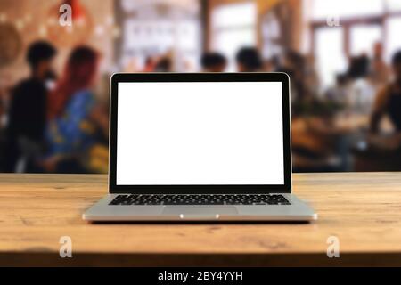 Mockup blank screen laptop on wood table in co-working space. Coffee Restaurant Stock Photo
