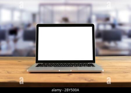 Mockup blank screen laptop on wood table in co-working space. Stock Photo