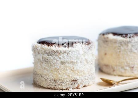 Homemade coconut cake with chocolate on a plate isolated Stock Photo