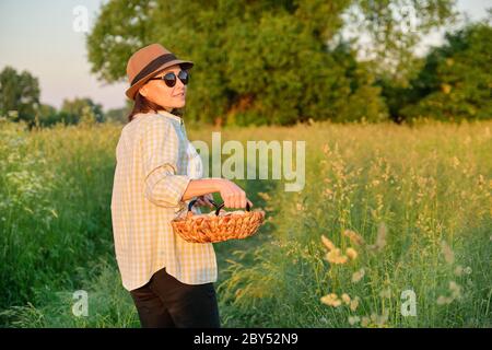 Portrait of farmer woman in hat with basket of fresh egg Stock Photo
