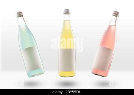 three glass bottles of lemonade and fizzy drinks, with empty mockup labels. yellow, pink and light green. Blank for designers. Stock Photo