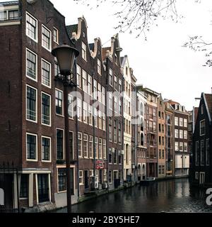 Typical water canal - gracht - and narrow houses along it in Amsterdam city centre, Netherlands Stock Photo