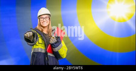 a young, confident engineer with clipboard advertises her job Stock Photo