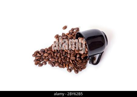 Spilled coffee beans from the black ceramic cup isolated on white background. Ideal for coffee menu. Stock Photo