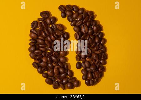 coffee beans on a yellow background, concert coffee symbol Stock Photo