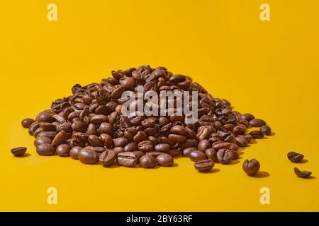 Coffee beans on a yellow background. Contrasting colors, minimalism Stock Photo