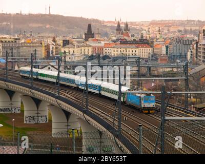 Train leaving Prague main railway station over new bridge with panorama of city centre on background, Czech Republic Stock Photo