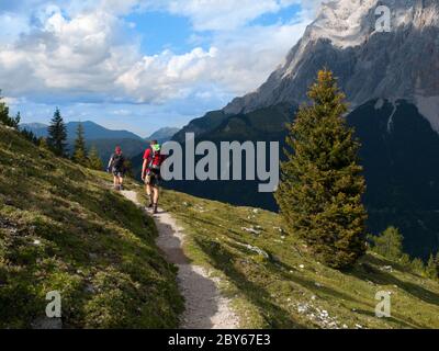 Young men trekking in Alps. Hiking on the narrow path in Zugspitze Area, Austria Stock Photo