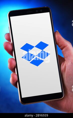 POZNAN, POL - MAY 21, 2020: Hand holding smartphone displaying logo of Dropbox, a file hosting service operated by Dropbox, Inc., headquartered in San Stock Photo