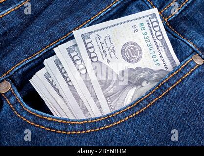 Dollar banknotes in the pockets of jeans trousers Stock Photo