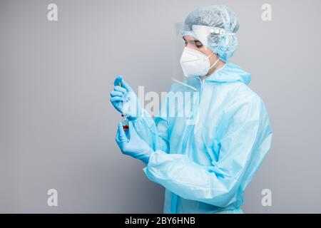 Profile photo of professional guy expert doc virologist prepare antidote bottle injection wear mask hazmat blue uniform suit plastic facial protective Stock Photo