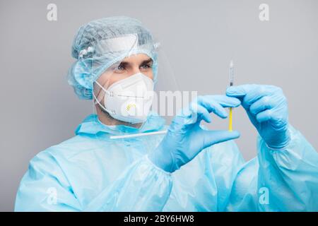 Closeup photo of professional guy expert doc virologist clinic prepare antidote injection wear mask hazmat blue uniform suit plastic facial protective Stock Photo