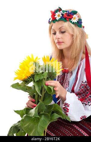 Woman wears Ukrainian dress is holding a sunflower Stock Photo