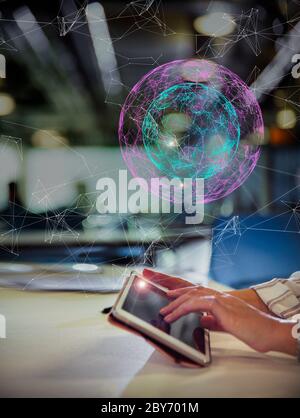 Digital globe above businesswoman suing digital tablet Stock Photo