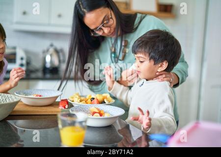 Family eating fruit in kitchen Stock Photo