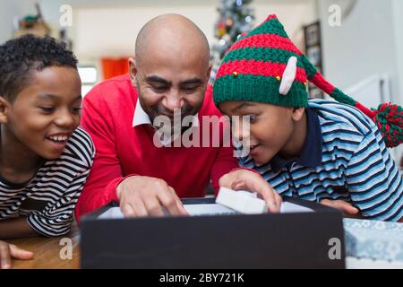 Father and sons opening Christmas gift Stock Photo