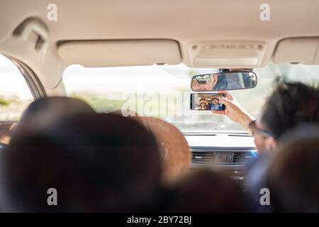 Family taking selfie with camera phone inside car Stock Photo