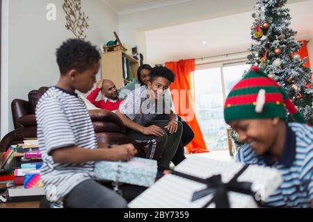 Family opening Christmas gifts in living room Stock Photo