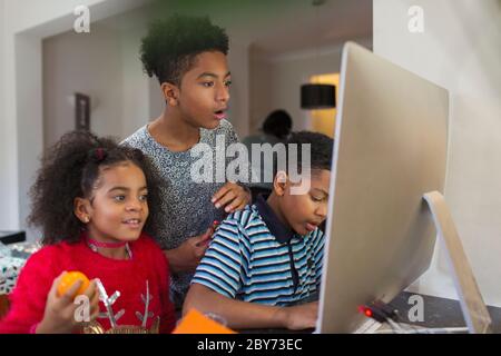 Brothers and sister using computer Stock Photo
