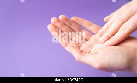 Moisturize hands with lotion. Woman applying moisturizing cream on hands. Body care. Isolated. Hand massage. Stock Photo