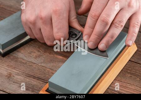 https://l450v.alamy.com/450v/2by7607/man-sharpening-a-pocket-knife-using-a-whetstone-2by7607.jpg