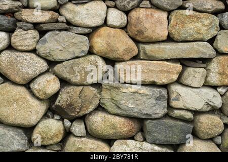Rock wall of natural rounded river stones Stock Photo
