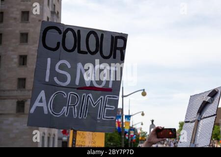 A protester holds a protest sign reading 