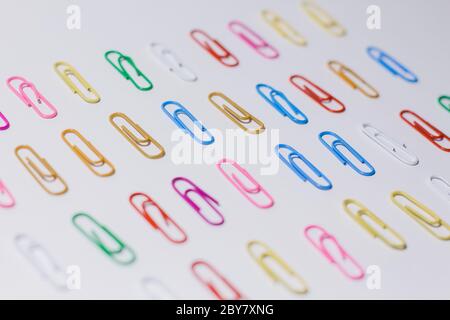 multicolored paper clips on white background Stock Photo