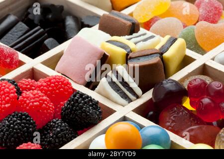 partitioned wooden box filled with a variety of sweets Stock Photo