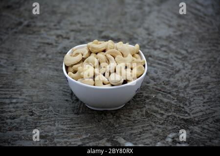 Tasty cashew nuts in bowl on a old wooden table Stock Photo - Alamy
