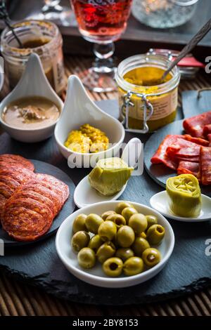 Assortment of tapas and antipasti on black background. Charcuterie boards of assorted appetizers. Stock Photo