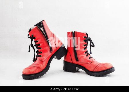 Pair of old leather red discarded boots with laces Stock Photo