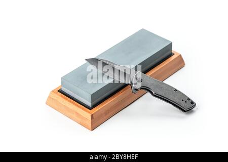 Black pocket knife and a whetstone isolated on white Stock Photo