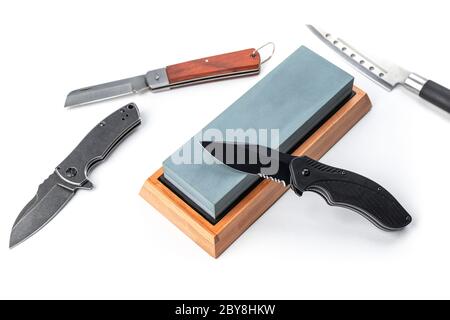 Various types of knives and a whetstone isolated on white background Stock Photo