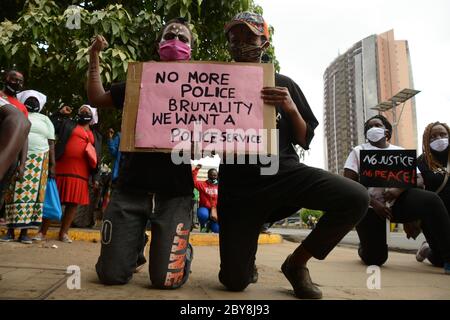 Nairobi, Kenya. 09th June, 2020. Two young residents of Mathare slums are seen holding a placard reading 'no more police brutality we want a police service' during the demonstrations.Residents of Mathare slums demonstrate outside the parliament building in a protest against police killings and brutality in the area while wearing facemasks with names of those who had been killed by police. Credit: SOPA Images Limited/Alamy Live News Stock Photo