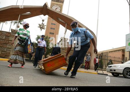 Nairobi, Kenya. 09th June, 2020. A police officer wearing a facmask drags an empty coffin that was abandoned by residents of Mathare slums outside the parliament building during the demonstrations.Residents of Mathare slums demonstrate outside the parliament building in a protest against police killings and brutality in the area while wearing facemasks with names of those who had been killed by police. Credit: SOPA Images Limited/Alamy Live News Stock Photo