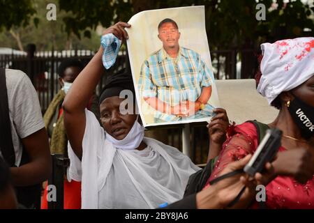 Nairobi, Kenya. 09th June, 2020. A woman from Mathare slums displays a photo of her loved one who was killed by police.Residents of Mathare slums demonstrate outside the parliament building in a protest against police killings and brutality in the area while wearing facemasks with names of those who had been killed by police. Credit: SOPA Images Limited/Alamy Live News Stock Photo