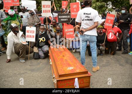 Nairobi, Kenya. 09th June, 2020. Residents of Mathare slums demonstrate outside parliament buildings while carrying placards and an empty coffin during the demonstrations.Residents of Mathare slums demonstrate outside the parliament building in a protest against police killings and brutality in the area while wearing facemasks with names of those who had been killed by police. Credit: SOPA Images Limited/Alamy Live News Stock Photo