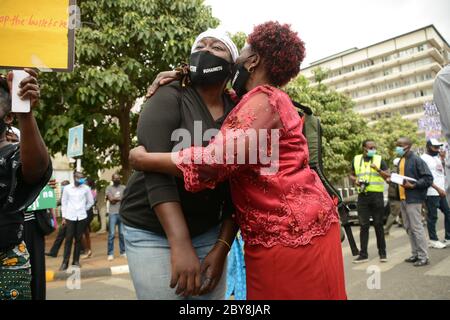 Nairobi, Kenya. 09th June, 2020. A woman wearing a facemask from Mathare slums consoles a fellow demonstrator who was overcome with emotions outside the parliament building during the demonstrations. Residents of Mathare slums demonstrate outside the parliament building in a protest against police killings and brutality in the area while wearing facemasks with names of those who had been killed by police. Credit: SOPA Images Limited/Alamy Live News Stock Photo