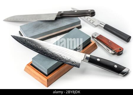 Assortment of various knives and whetstones on white background Stock Photo