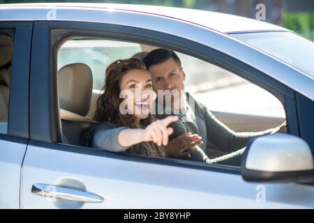 Young couple sitting in the car and looking at something Stock Photo