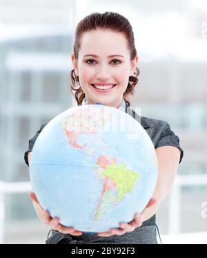 Charismatic businesswoman holding a terrestrial globe Stock Photo