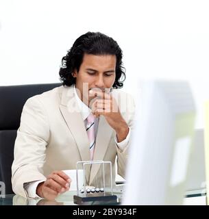 Close-up of serious businessman playing with kinetic balls Stock Photo