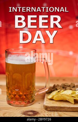 A glass of beer and different snacks on the table. Celebrating international beer day or Octoberfest. Drinking beer after a hard working day or week Stock Photo