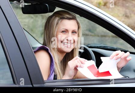 Jolly young female driver tearing up her L sign Stock Photo