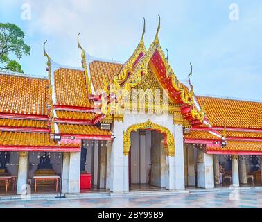 BANGKOK, THAILAND - MAY 13, 2019: The complex pyathat roof of the gallery with gilt and mirror decors, carvings and curved finials, Wat Benchamabophit Stock Photo