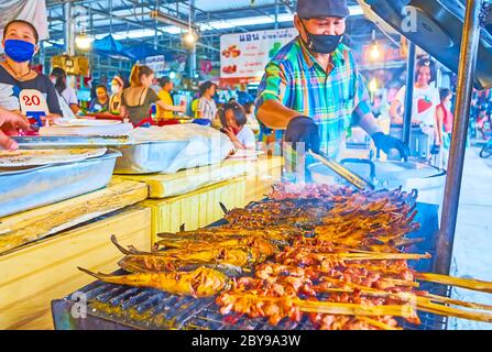 BANGKOK, THAILAND - MAY 13, 2019: The smoky reeky mackerel and pork on skewers, roasting on grill in Talad Saphan Phut market, on May 13 in Bangkok Stock Photo