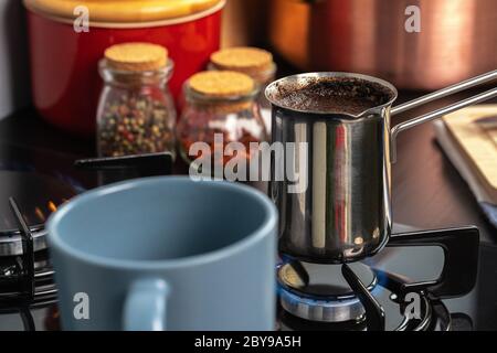 Brew coffee in a steel turk on a gas stove Stock Photo