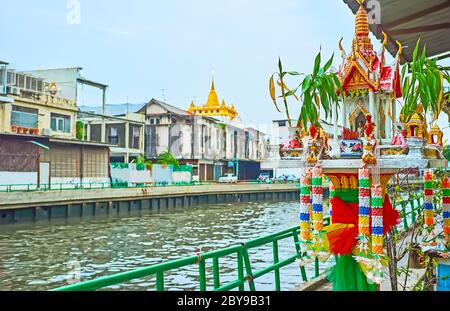The small mondop (pavilion) shrine, decorated with carvings, patterns, flower garlands and bouquets in vases, located at the Khlong Maha Nak, Bangkok, Stock Photo
