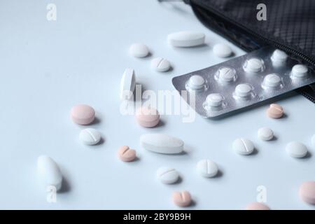 Top view of white pills spilling from container  Stock Photo